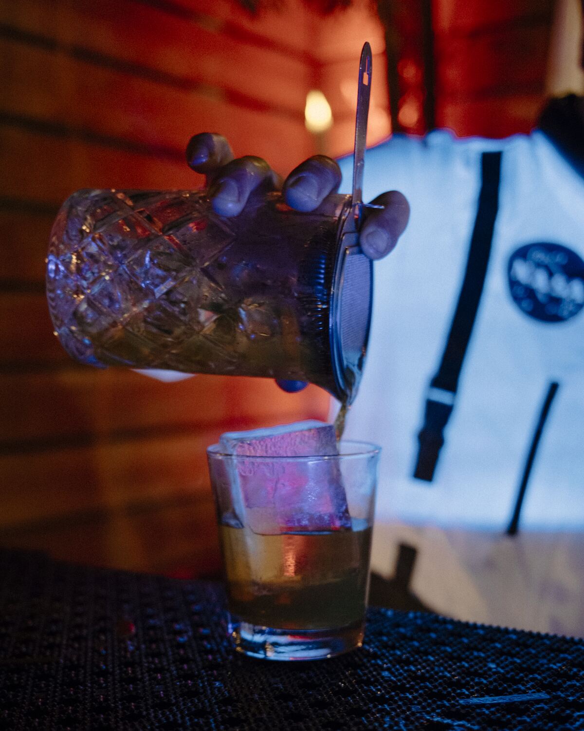A cocktail being stirred and poured
